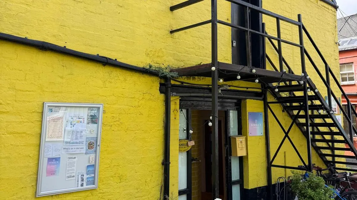 Fachada amarilla con escalera metálica negra