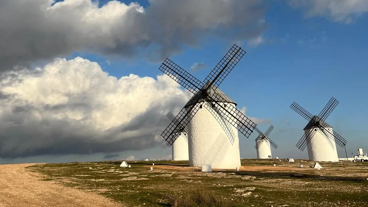 Molinos de viento blancos en La Mancha bajo un cielo con nubes